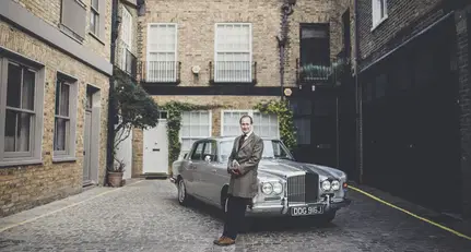 Graeme Hunt beside a classic motor car in a London courtyard