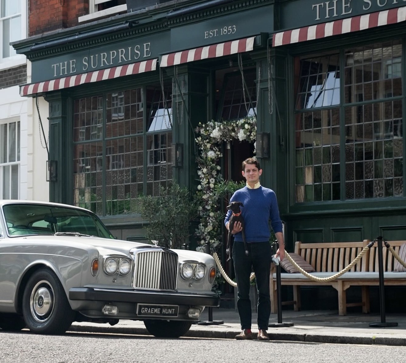 William Hunt beside a silver Bentley outside The Surprise in London